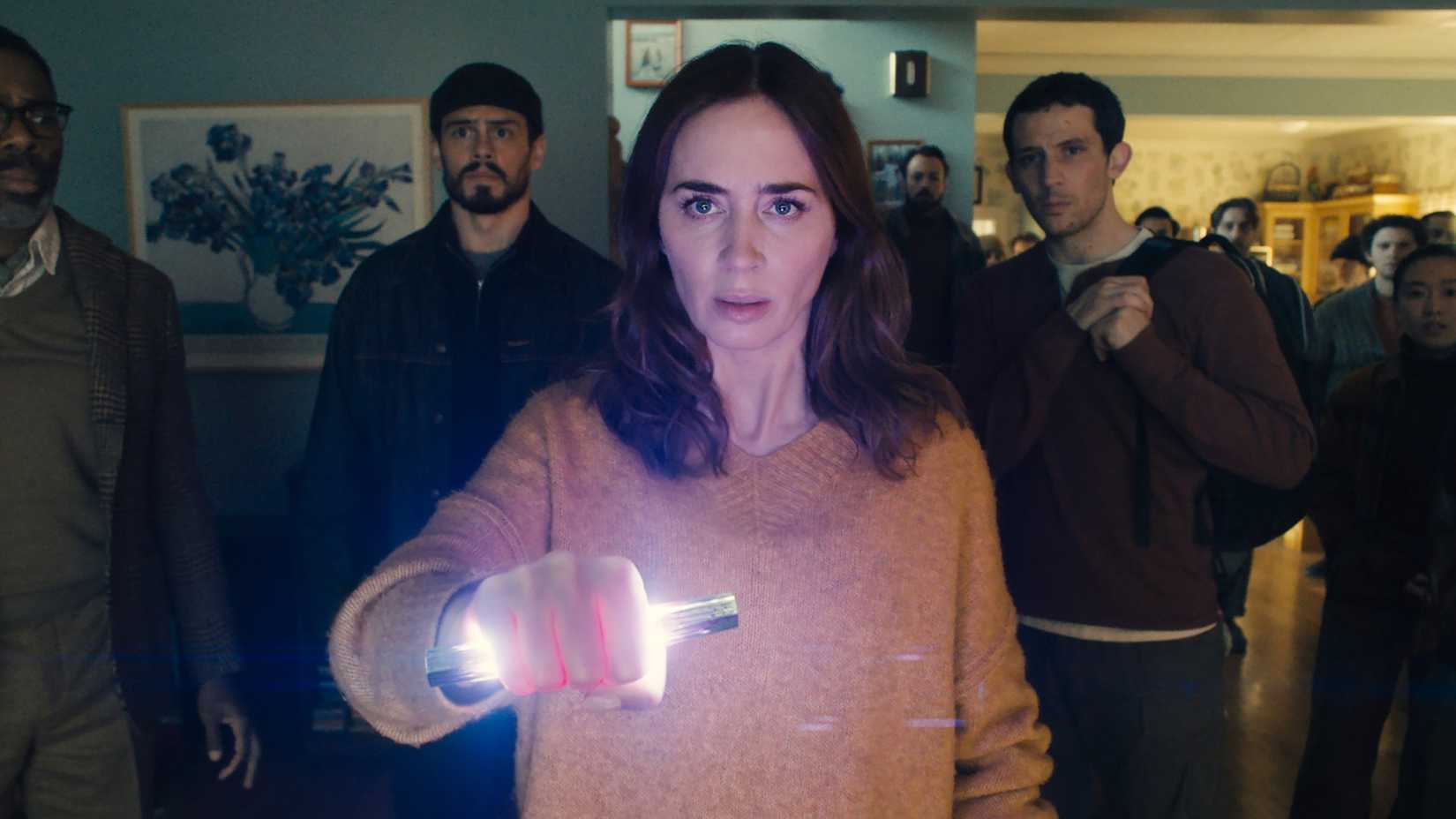 Margaret, interpretada por Emily Blunt, segura um artefato alienígena luminoso sob olhares preocupados em Disclosure Day