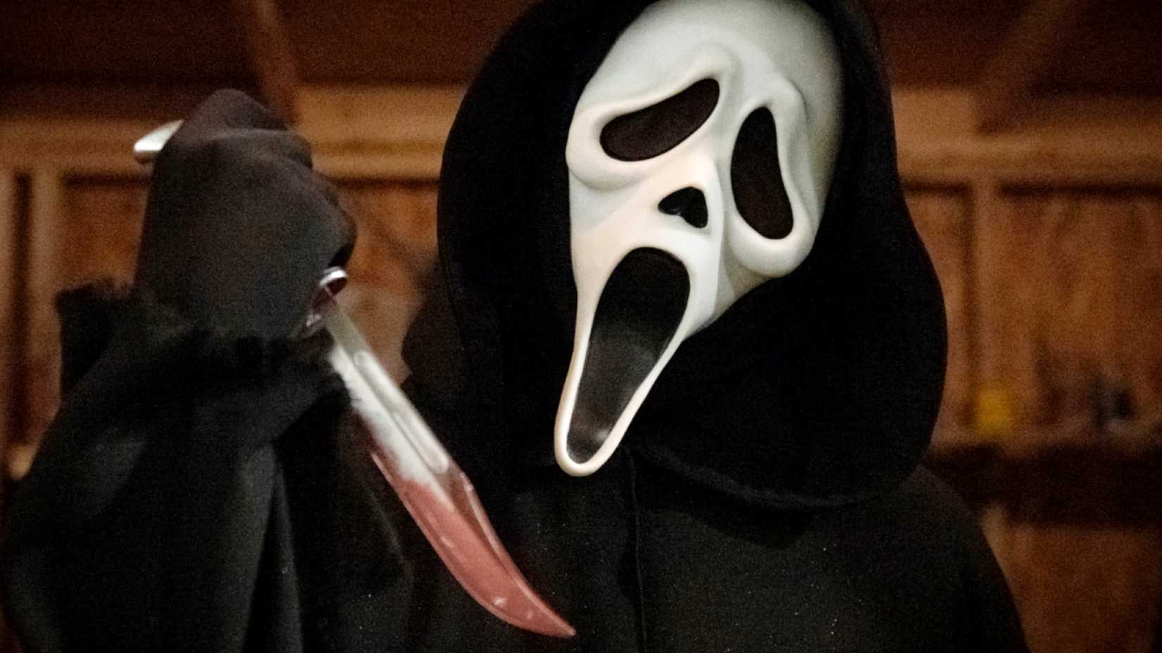 Ghostface segura faca ensanguentada em imagem promocional de Pânico (2022). Crédito: for Scream 2022
