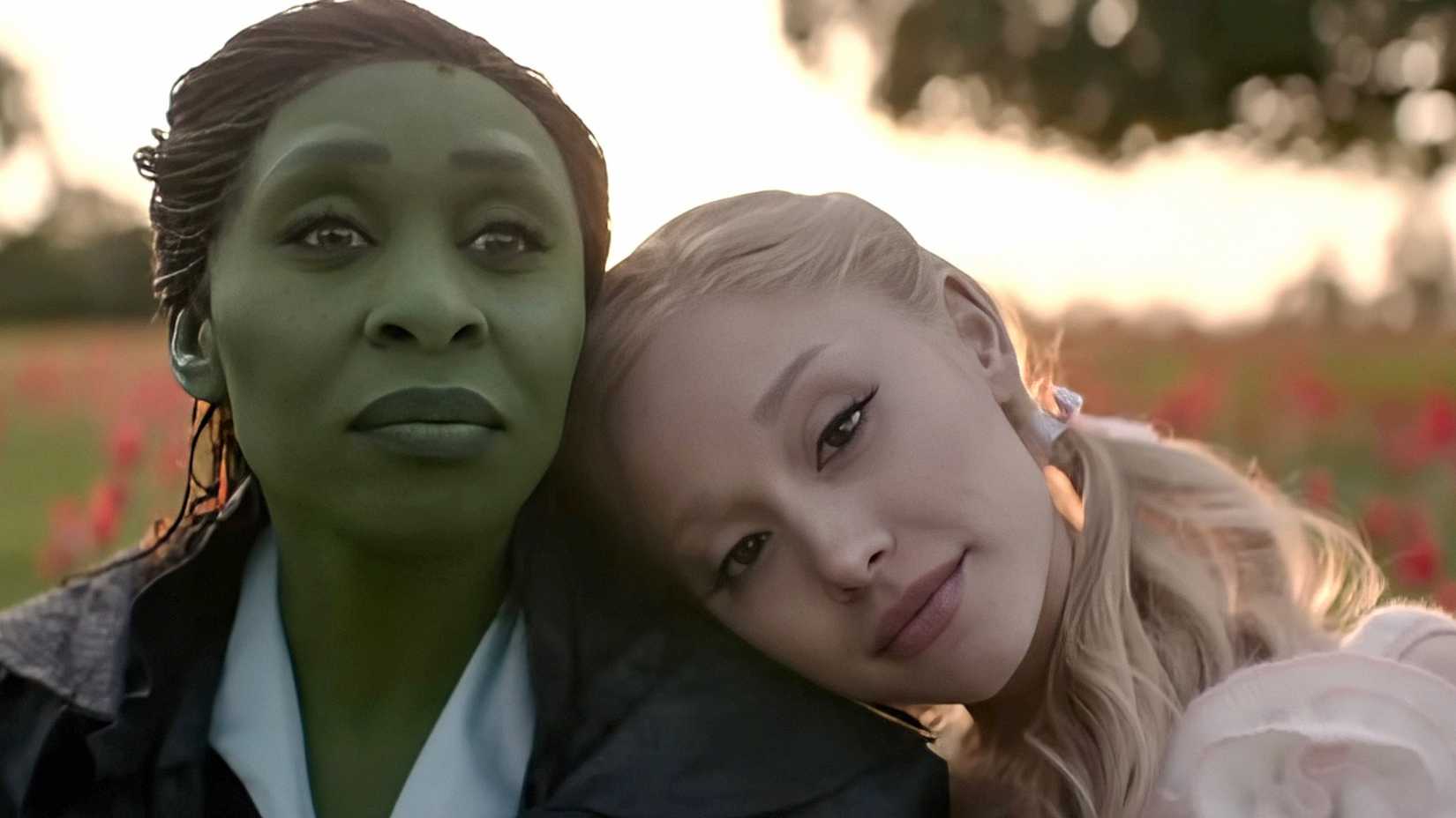 Glinda apoia a cabeça no ombro de Elphaba em cena de Wicked