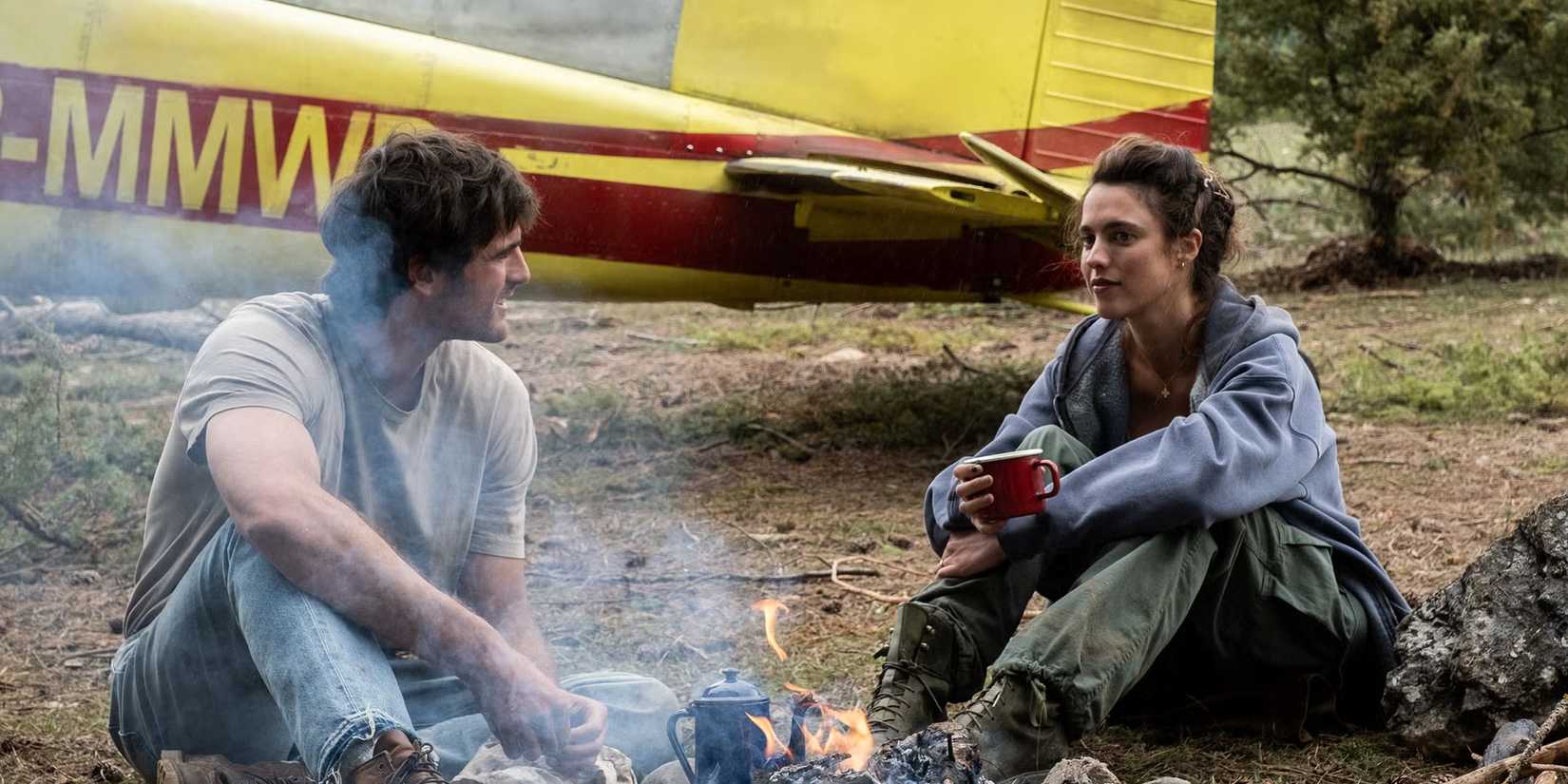 Jacob Elordi e Margaret Qualley ao redor de uma fogueira em The Dog Stars
