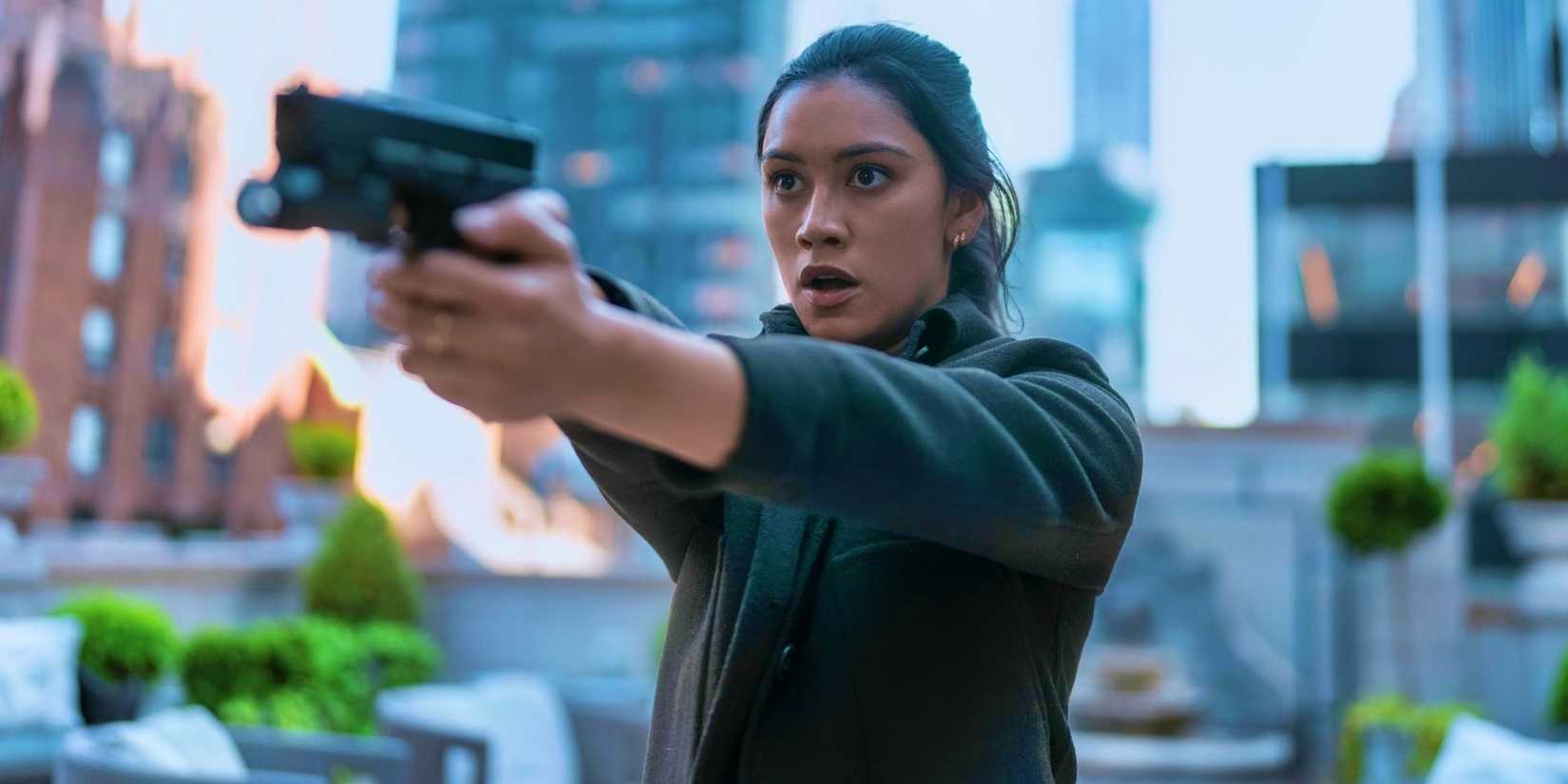 Luciane Buchanan como Rose aponta uma arma em The Night Agent