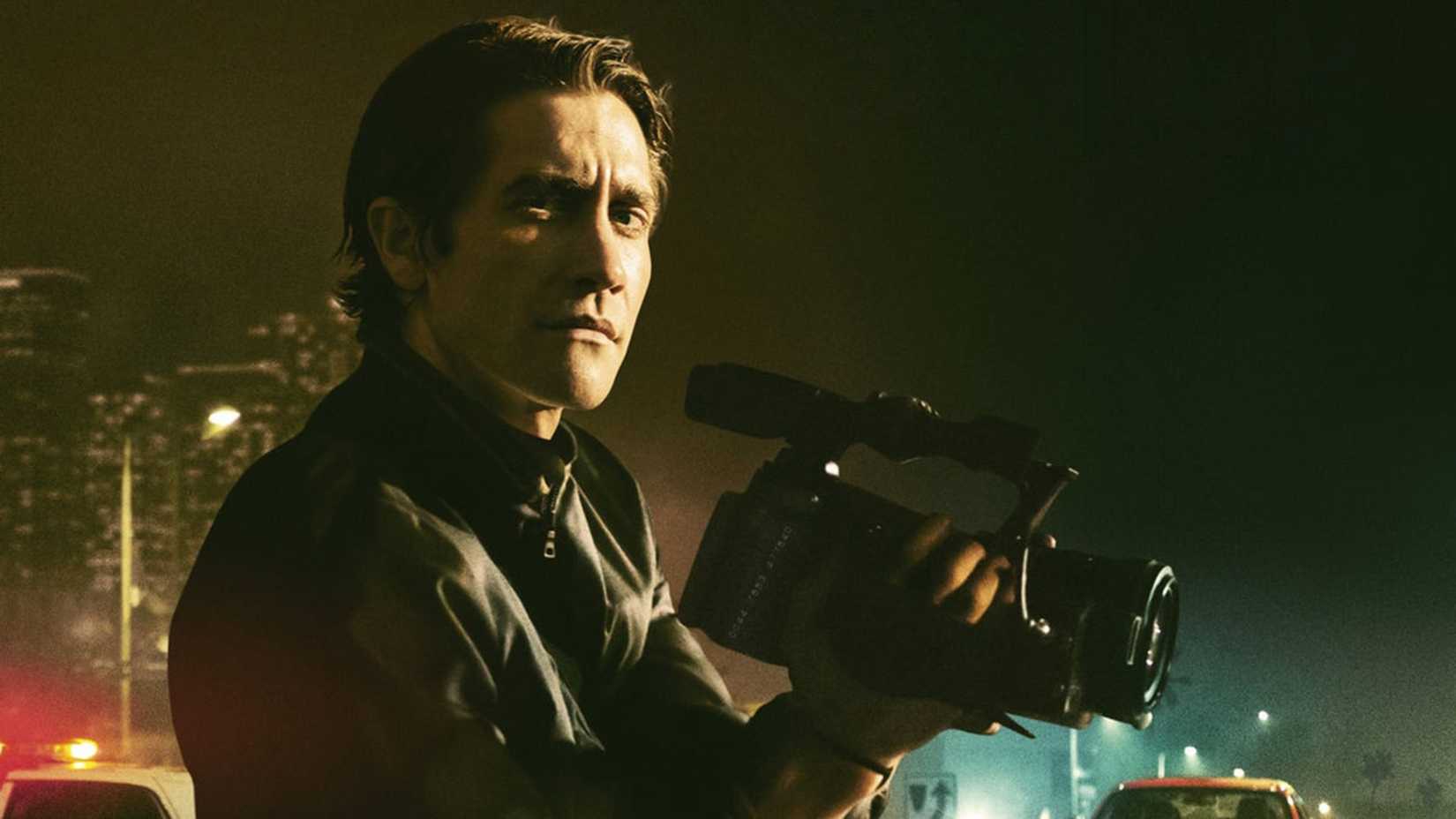 Jake Gyllenhaal segura uma câmera com a cidade ao fundo em O Abutre