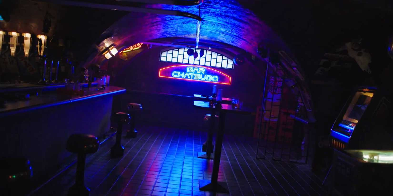 Interior do bar Chatsubo, iluminado por letreiro neon, em Neuromancer