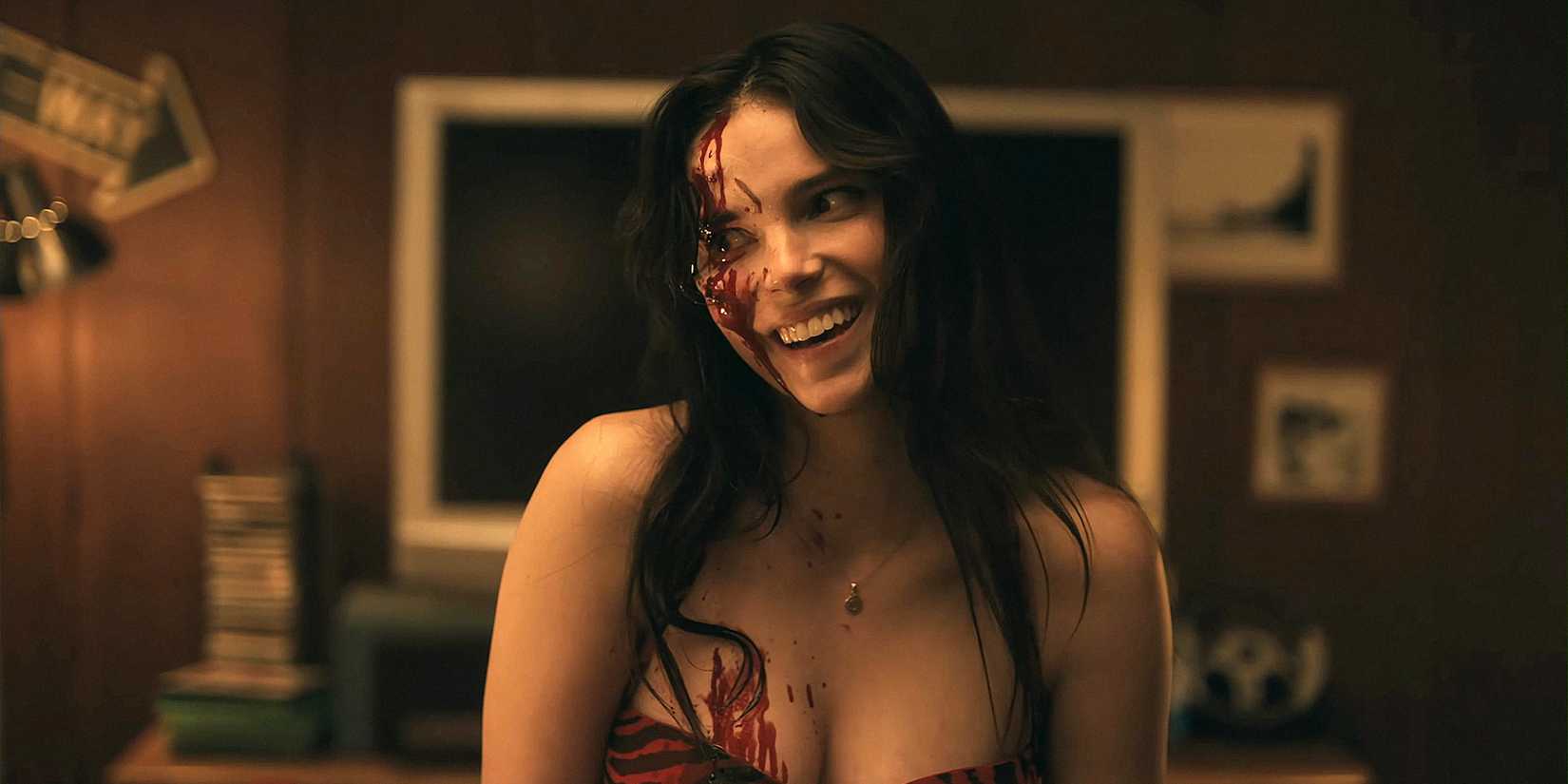 Nikki (Inde Navarrette) sorri, coberta de sangue, em cena de 'Obsession'