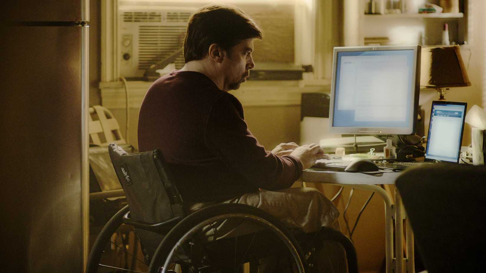 Sam Scales trabalha no computador em cena da 4ª temporada de O Poder e a Lei