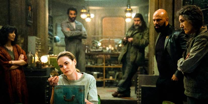 Juliette examina uma moeda grande observada por Lukas, Patrick Kennedy, Sims e Martha em cena da 3ª temporada